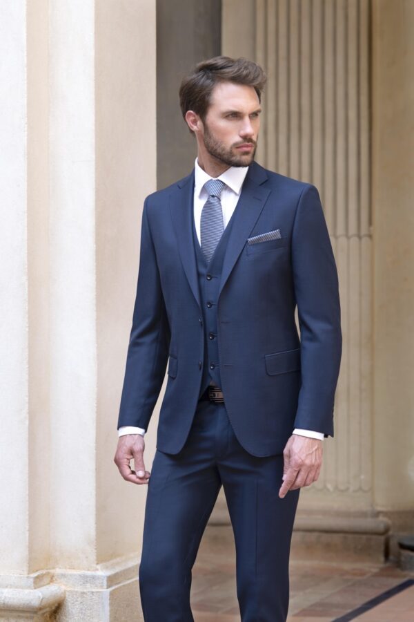 Traje azul marino con chaleco y corbata azul a juego