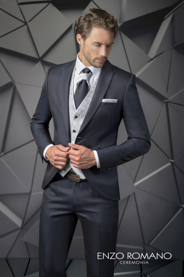 Traje azul oscuro con chaleco claro y corbata gris